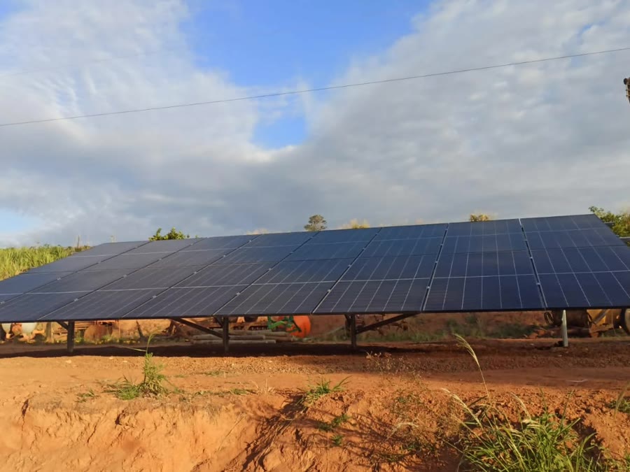 Usina solar instalada pela Sollivre no solo de um sítio em Ouro Fino, com 16 módulos em estrutura metálica e canavial ao fundo